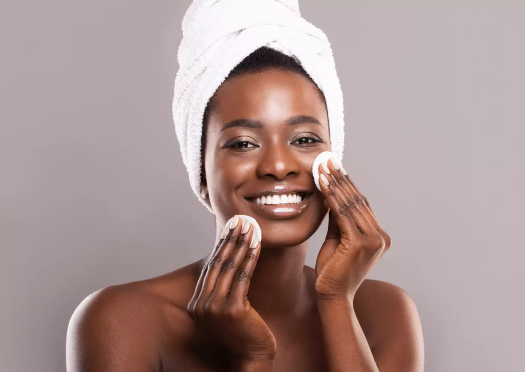 Femme à la peau noire en train de faire sa routine skincare 