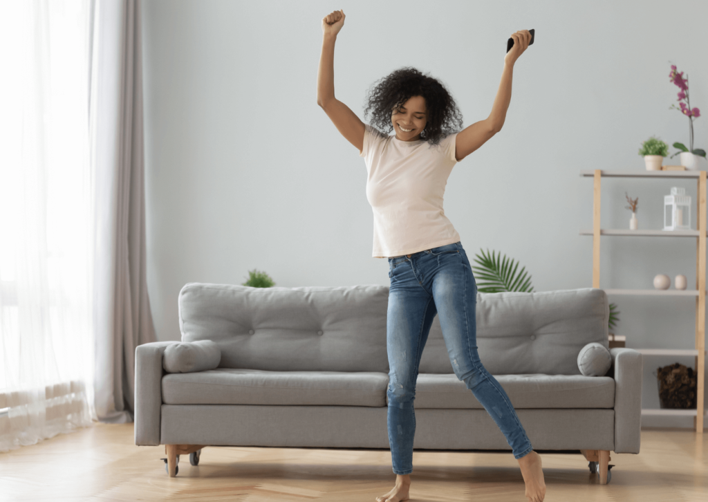 Femme métisse qui danse dans son salon