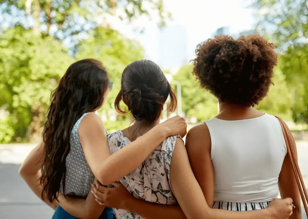 Trois femmes de dos qui se tiennent pas la taille